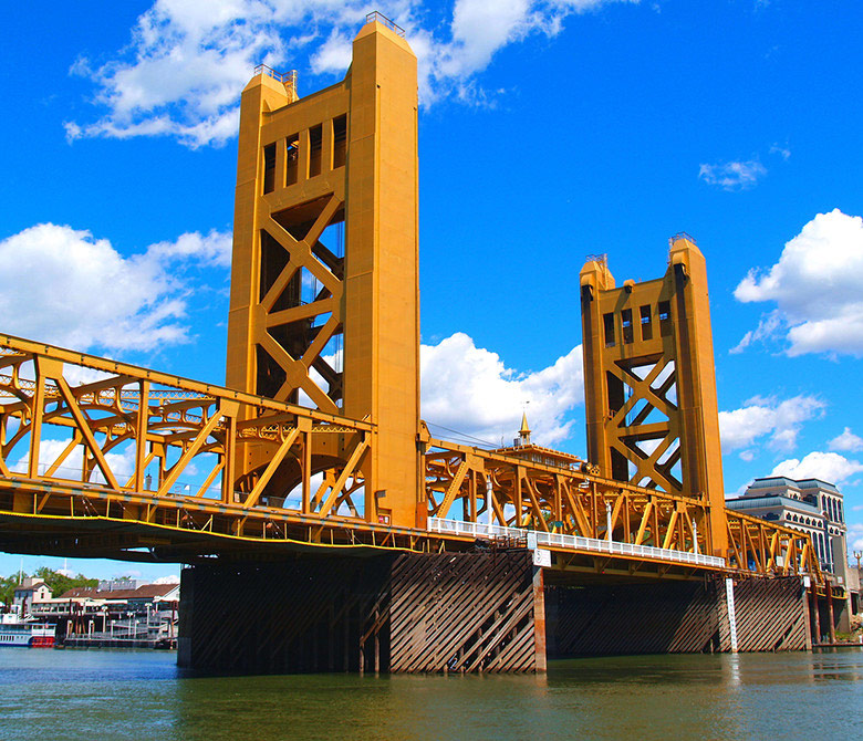 an image of the Tower Bridge in West Sacramento with a bright blue, slightly cloudy sky in the background